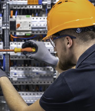 a-male-electrician-works-in-a-switchboard-with-an-2024-04-16-19-04-10-utc A male electrician works in a switchboard with an electrical connecting cable. Young adult electrician civil engineer screwing equipment into fuse box. SSUCv3H4sIAAAAAAAACpySy47DIAxF9yPNP0SsGykNebW/Us3CPNqgUqiAdDSq+u9jIKmY7eziY/vaF+f5+VFVhIFXnByrZ4wwVlovPjgIyhrEzW7lThohXUkejg5NCUCVkRQqWKdAl5BB4LOBm0RoFq0jfqUk8QHC4qWPu6yIQ5AX1MjwLZEXPuW42hIpiR2YImRXML+wxDaUxf/VmT++3oYv0vCftHBhxEktIRs55VJy/Q7S3UprsAhlC1cPy0HHAloogbqDgz99d6e4MpeC2DCnu2xK3C4muLjV2wzR1t6B6fjqZxwjNz6D91guNl7M5vgX2Fsxx9iQPK2qROBxYrintO8n2g8HOrX92HbdWpAPOivUSetsQhjzqxKlKxU3IHIaBnpmU93w9lB3g2jrwziyemrY1O2B8pE3eIvXLwAAAP//AwAuBp8+uQIAAA==